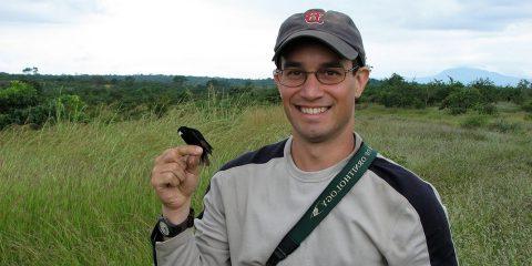 A man with a bird perched in his finger